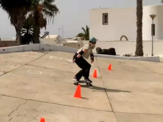 A young woman practicing surfkating in a park that mimics a waves