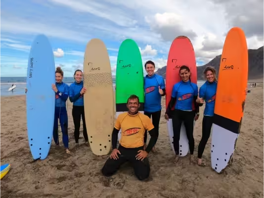 Conrad, the coach of the surfschool, with five students  after a lesson for beginners and beginners with prior experience at Playa de Famara.